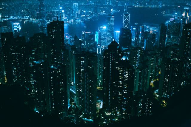 City skyline at night with illuminated buildings in blue tones