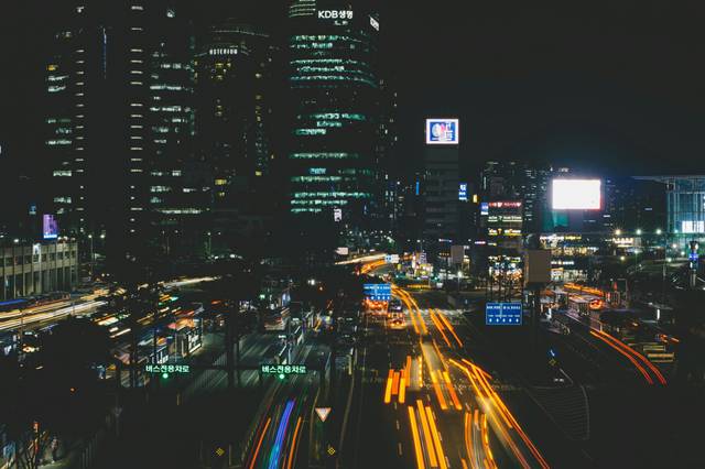Long exposure cityscape showing traffic light trails through busy intersection