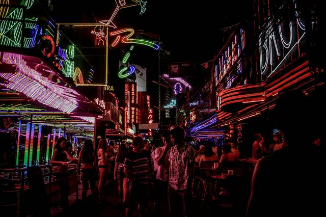 Vibrant neon-lit street scene with colorful signs and crowds