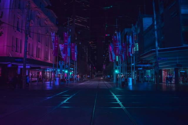 Modern city street at night with blue and magenta lighting