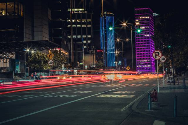 Urban street at night with light trails and illuminated buildings
